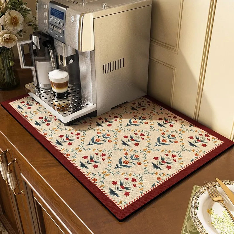 Tapis-de-séchage-de-vaisselle-fleuri-contour-bourgogne-sur-comptoir-sous-une-cafetière